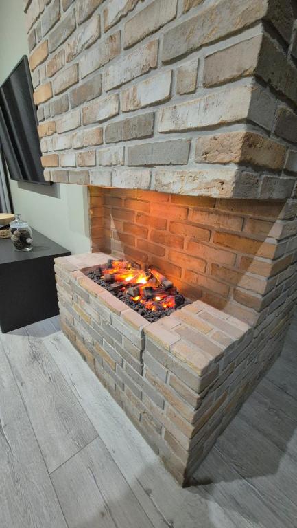 a brick fireplace in a room with a brick wall at Boznicza Old Town LUX Apartment, self check-in 24h, free parking in Poznań