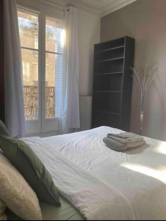 une chambre avec un lit avec deux serviettes dessus dans l'établissement Beautiful Flat Champs-Elysée, à Paris