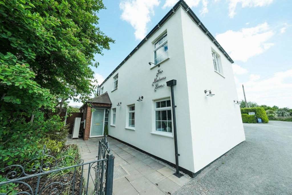 an exterior view of a white house with a driveway at The Machine House - Hot Tub - Outdoor Bar in Ashby de la Zouch