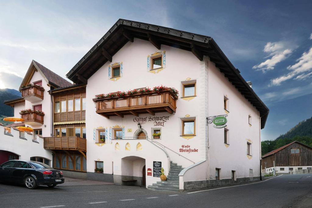 un edificio blanco con techo de madera en Hotel Schwarzer Adler en Resia