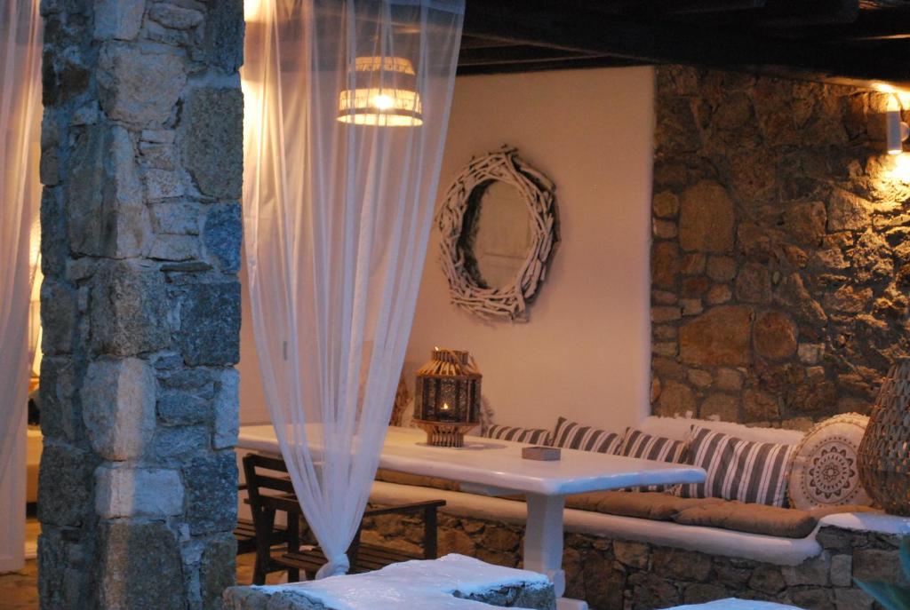 a table in a room with a stone wall at Blue Island Maisonette with Sharing Pool in Mýkonos City