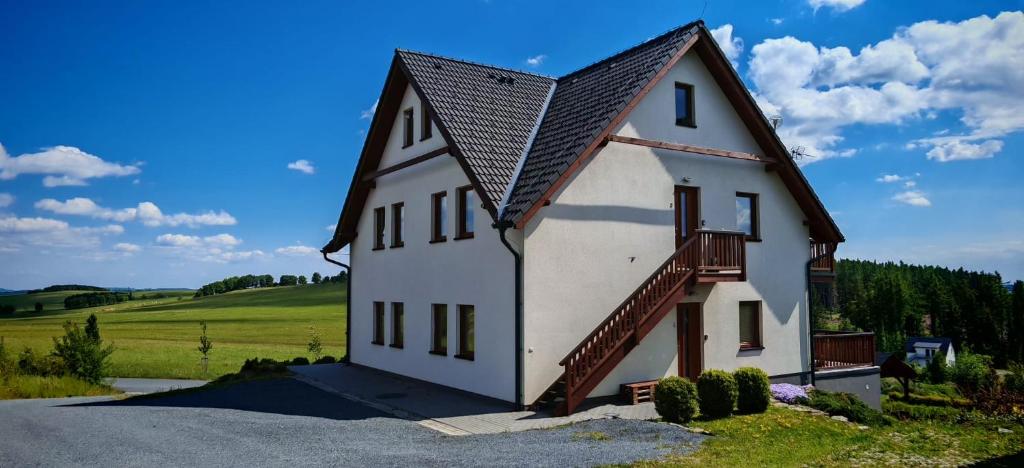 una gran casa blanca con techo de gambrel en Apartmán Hluchá sova, en Horní Václavov