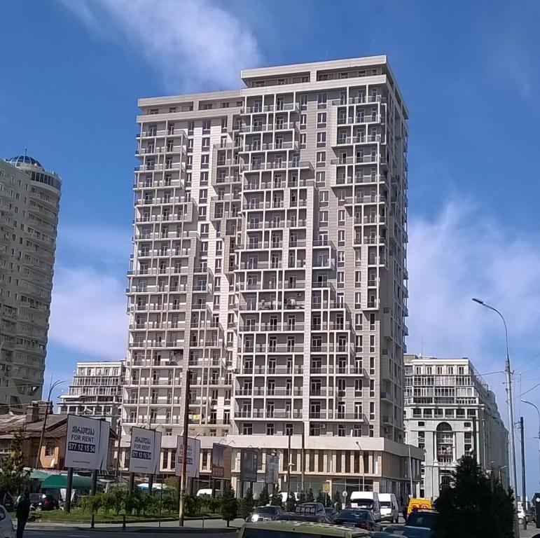 um edifício branco alto com muitas janelas em Buoy Rooms em Batumi