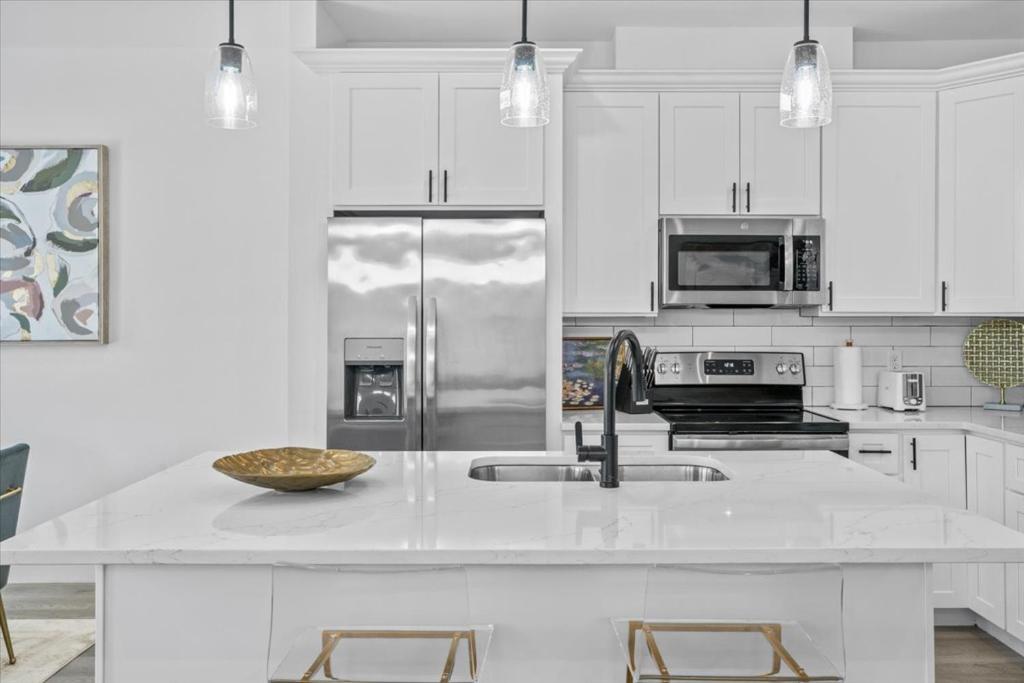 Una cocina con gabinetes blancos y una gran encimera blanca. en High Style in H-Town with Luxury near Downtown, en Houston