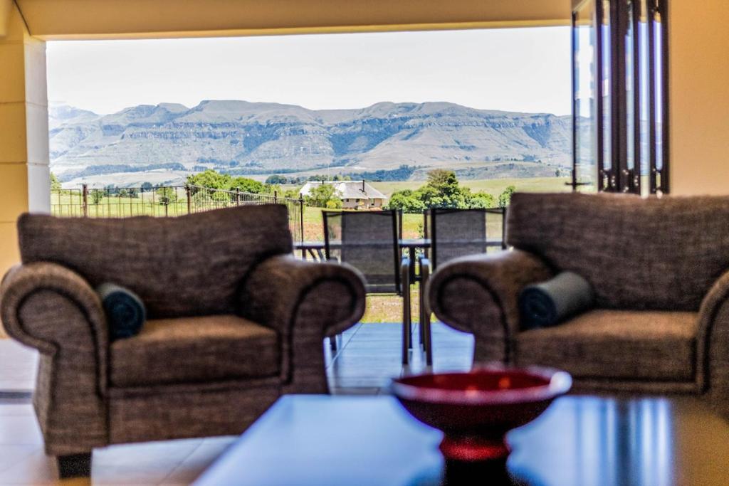 two chairs in a living room with a view of mountains at Serenity, Cathkin Estates by Euphoric Leisure in Winterton
