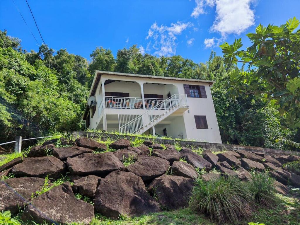 a house on top of a hill with rocks at Mamie Kaz in Vieux-Habitants