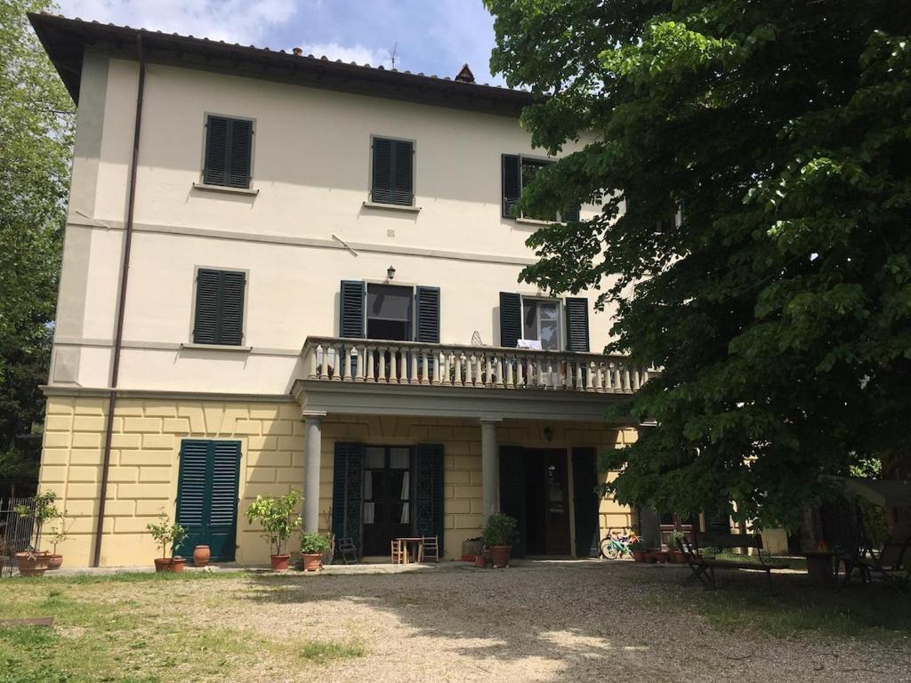a large white house with a balcony on it at Apartment in ancient historic villa near Florence in Rufina