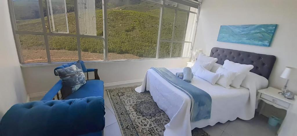 a bedroom with a bed and a couch and a window at Keith's Condo in Cape Town
