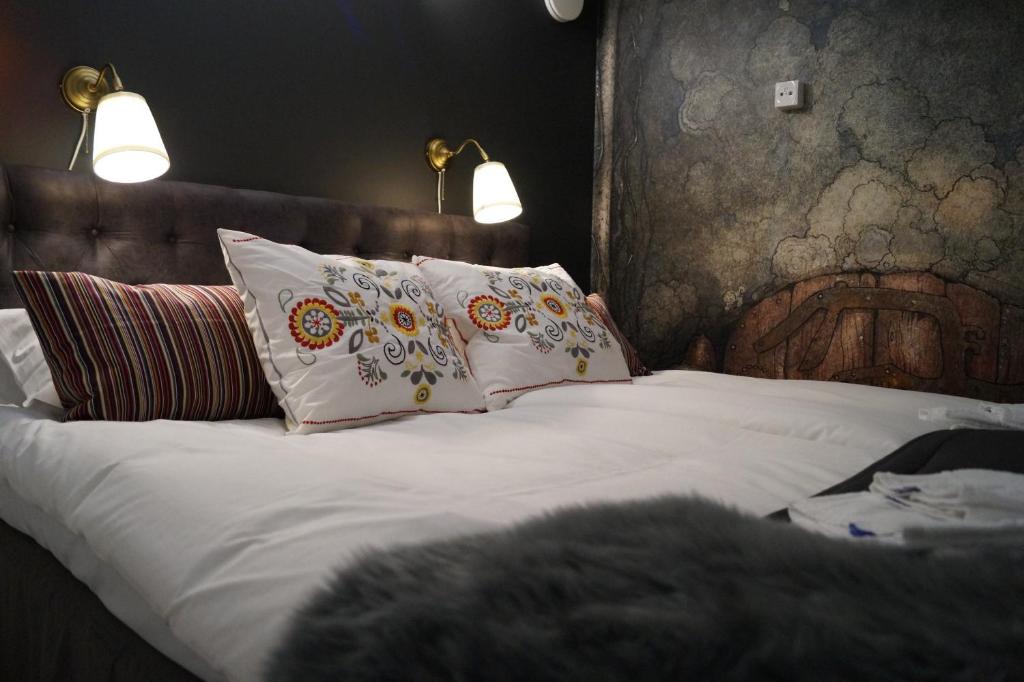 a bed with white sheets and pillows on it at Hotell Skeppsbron in Stockholm