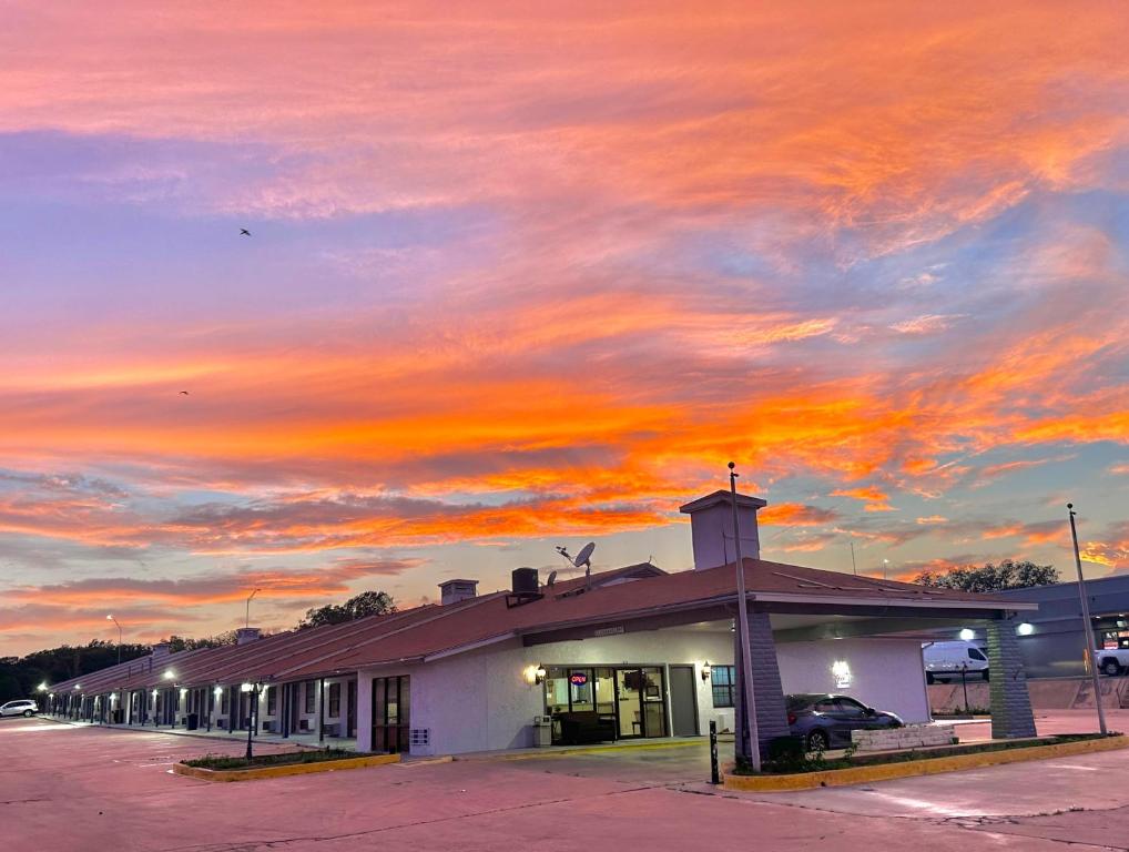 a building with a sunset in the sky at Sunset Inn in Brady