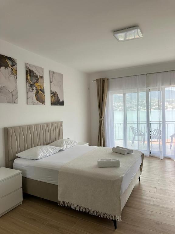 a bedroom with a large bed and a balcony at Bellanti in Herceg-Novi