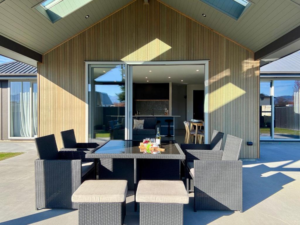 a patio with a table and chairs and a building at OHAU I Love 15 in Twizel