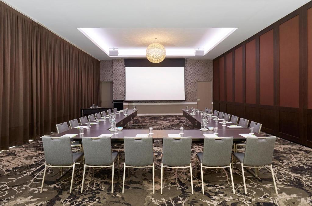 a conference room with a long table and chairs at Holiday Inn Warwick Farm by IHG in Warwick Farm