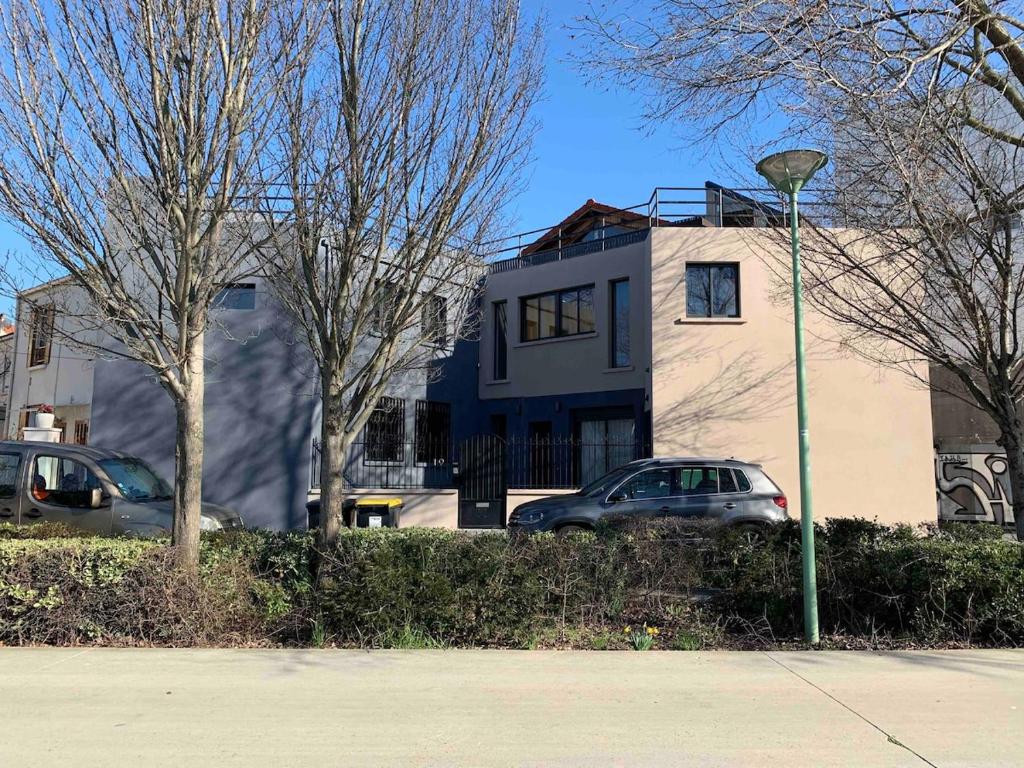 a house with cars parked in front of a street light at Contemporary house stadium of france in Saint-Denis