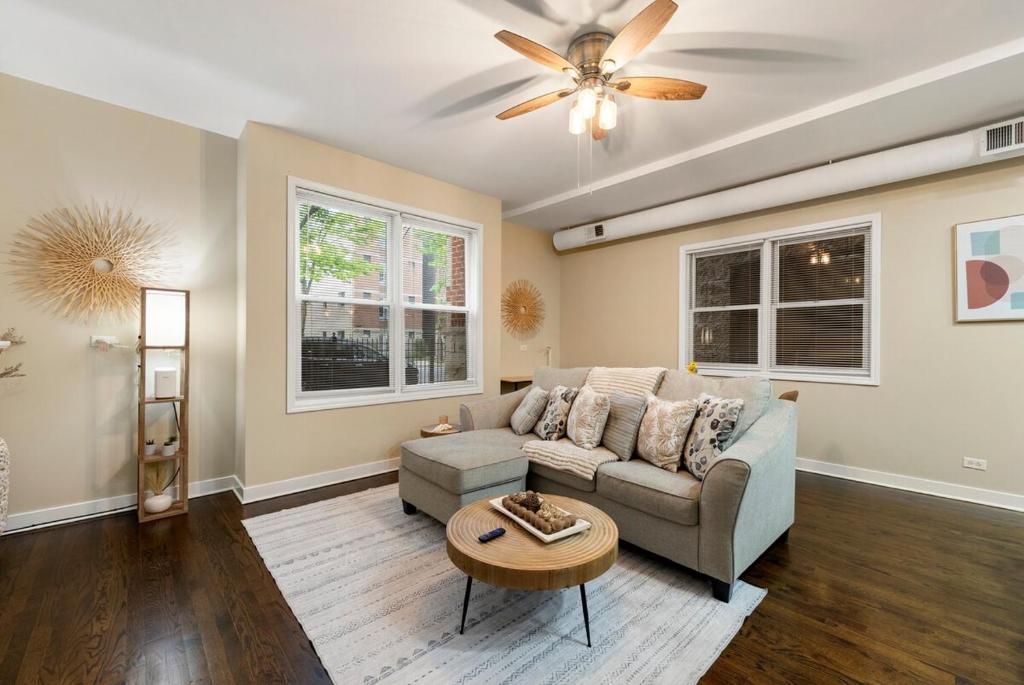 Una sala de estar con un sofá y un ventilador de techo. en Quick Drive to Downtown Chicago & Early Check-In, en Chicago