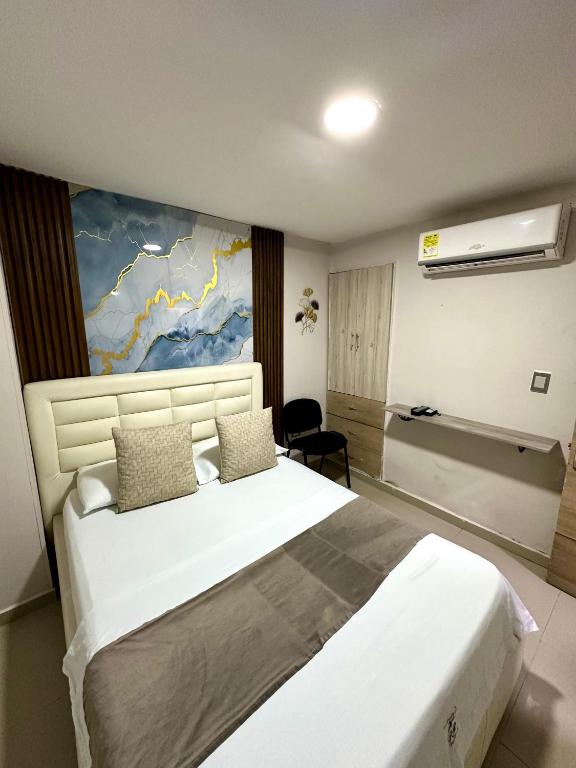 a bedroom with a large bed with a painting on the wall at GRAN HORIZON RODADERO Santa Marta in Santa Marta