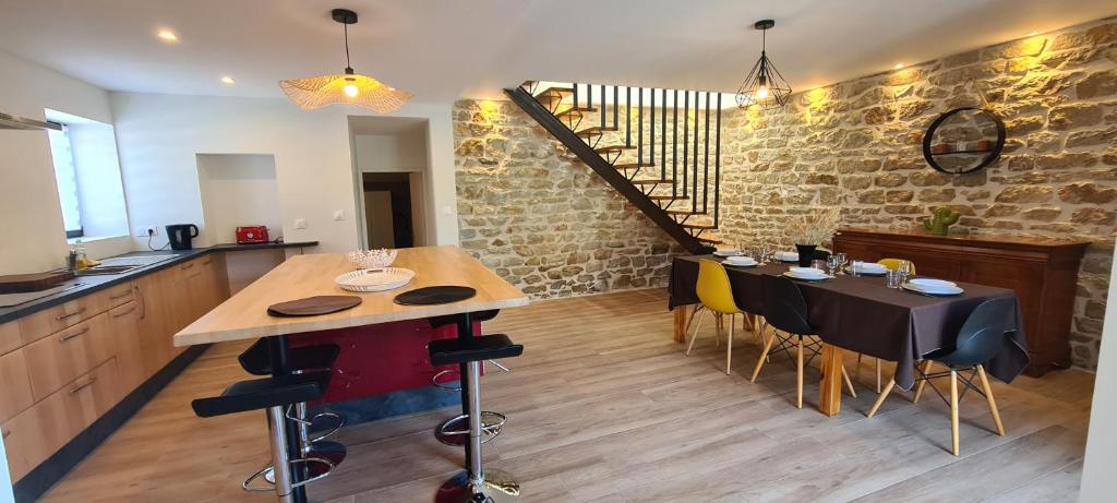 a kitchen with a table and chairs and a staircase at Maison entièrement rénovée, jardin & terrasse à 5min des plages in Combrit
