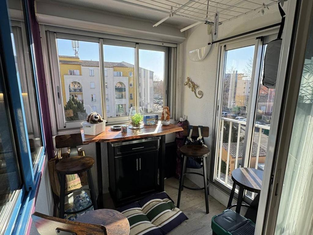 une petite cuisine avec un comptoir dans une pièce avec des fenêtres dans l'établissement Confortable T2 au Cap d'Agde avec WiFi et parking, animaux acceptés - FR-1-749-103, au Cap d'Agde