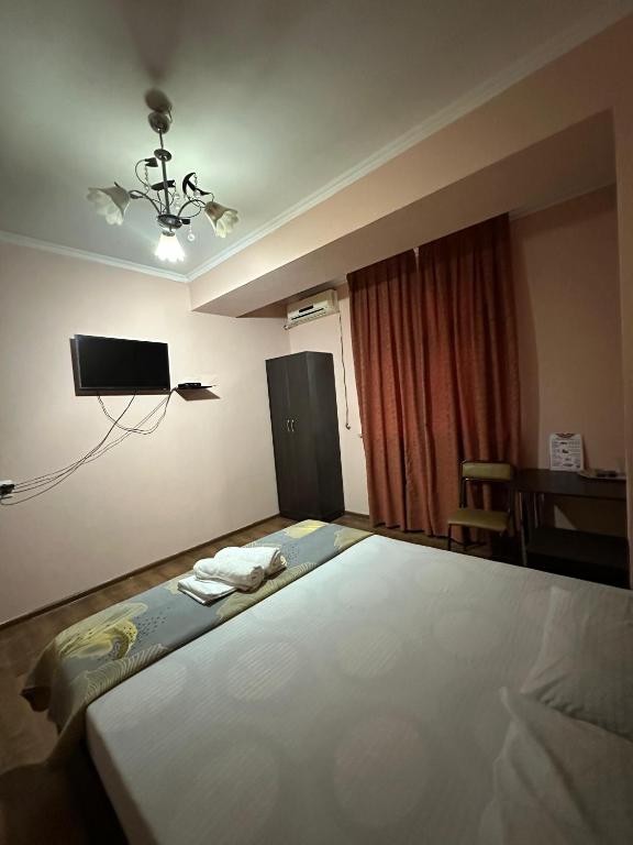 a bedroom with a large bed with a tv on the wall at Ак сункар in Zhezdi