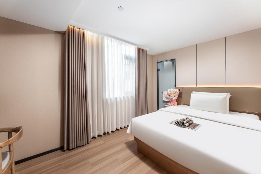 Postel nebo postele na pokoji v ubytování Guangzhou JinTang Hotel