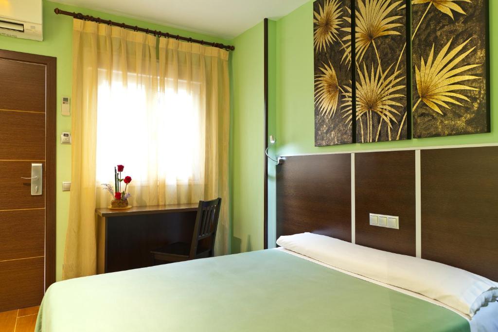 um quarto com uma cama grande e uma janela em Hostal Avenida Barajas em Madri
