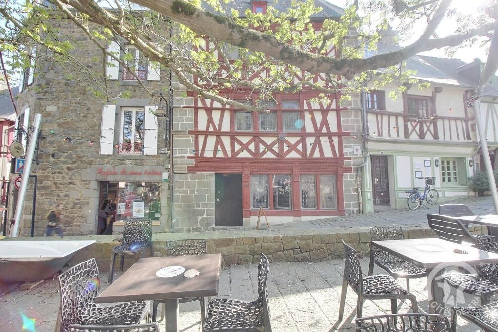 a patio with tables and chairs in front of a building at Hotel des ducs de bretagne in Saint-Brieuc