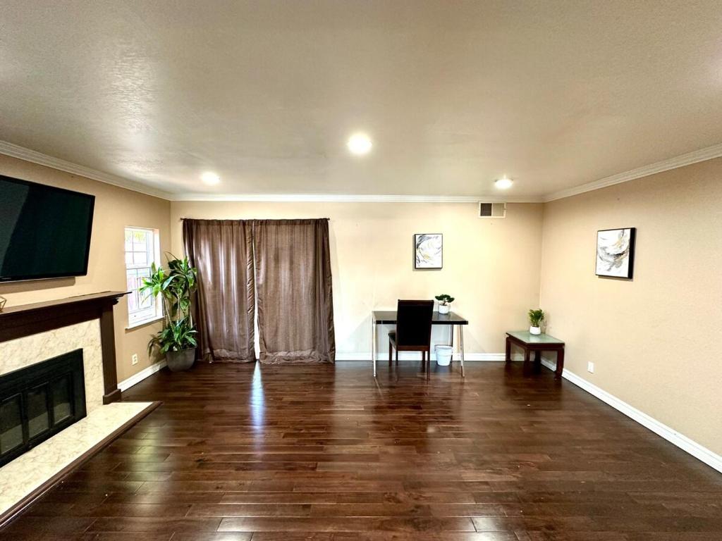 an empty living room with a table and a television at Relax at 4Bedrooms retreat nearby Apple in Santa Clara