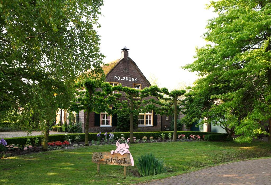 a woman sitting on a bench in front of a building at Appartement Hoeve Polsdonk in Oirschot