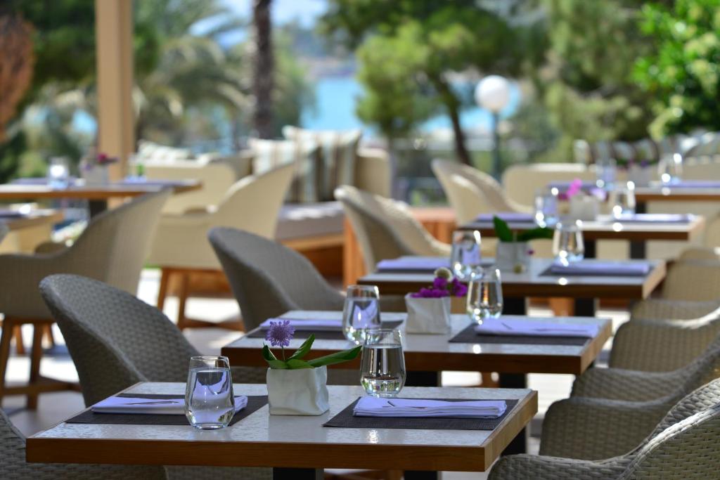 a row of tables and chairs in a restaurant at Somewhere Vouliagmeni in Athens