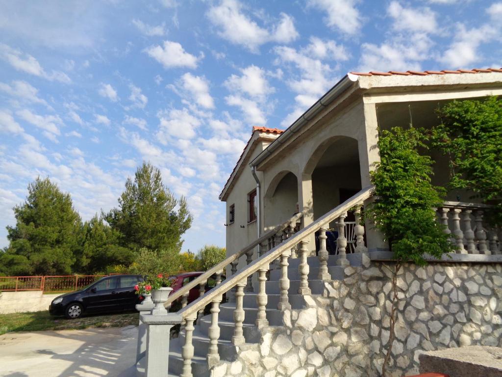 une maison avec un mur en pierre et des escaliers dans l'établissement Maslina Apartment, à Jadrtovac