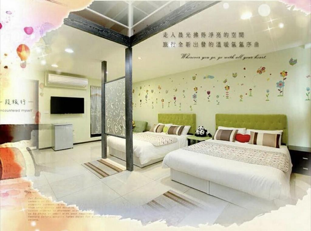 a bedroom with two beds and a wall with hello kitty stickers at 窩心の家民宿 in Suao