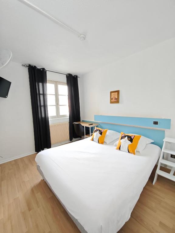 un grand lit blanc dans une chambre avec une fenêtre dans l'établissement La Route Des Vins, à Belleville-en-Beaujolais