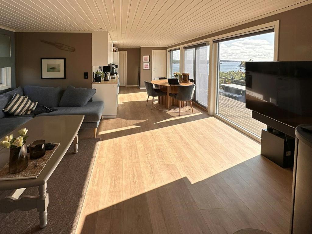 ein Wohnzimmer mit Sofa und Tisch in der Unterkunft Cabin With Views And A Large Terrace In Søgne in Søgne
