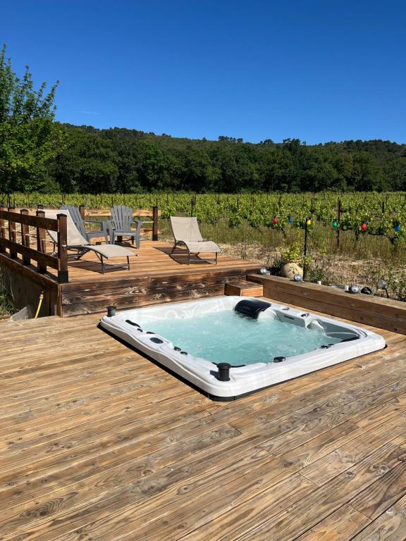 un bain à remous au-dessus d'une terrasse en bois dans l'établissement Entre mer et montagne, à Garéoult