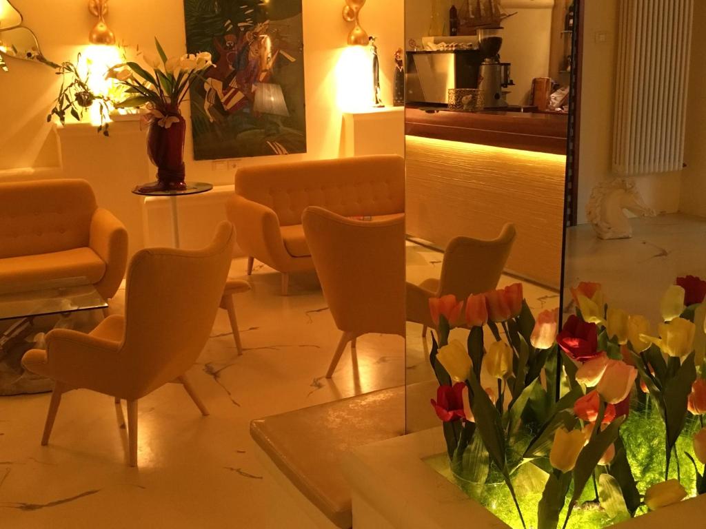 uma sala de estar com cadeiras e um vaso de flores em Hotel Derby em Bellaria-Igea Marina