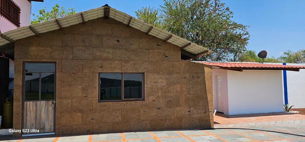 una piccola casa di mattoni con una finestra e un garage di Finca huaquechula a Cedro