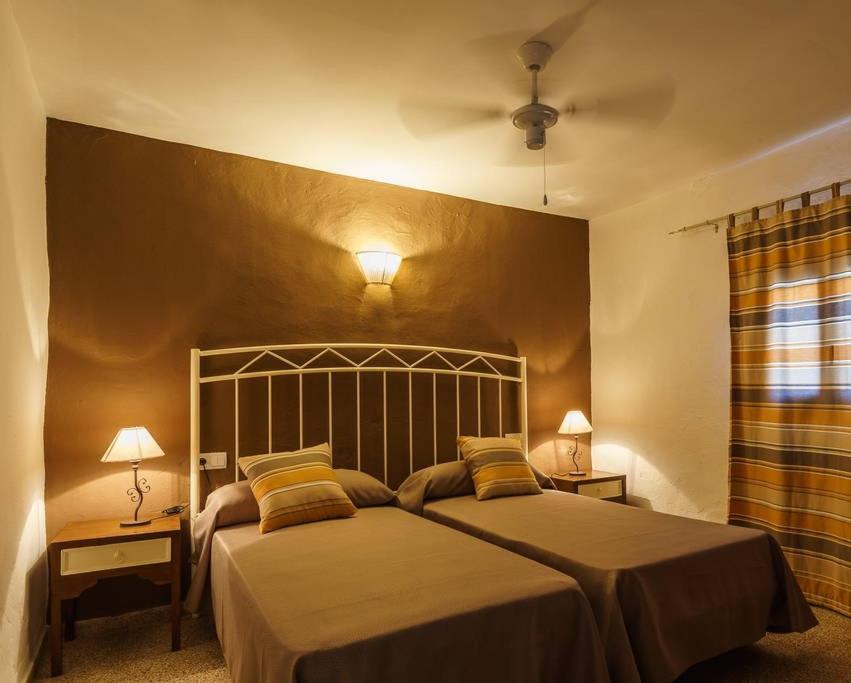 1 dormitorio con 1 cama grande con 2 lámparas y 2 mesas en Can Beia Rural House Ibiza, en Nuestra Señora de Jesús
