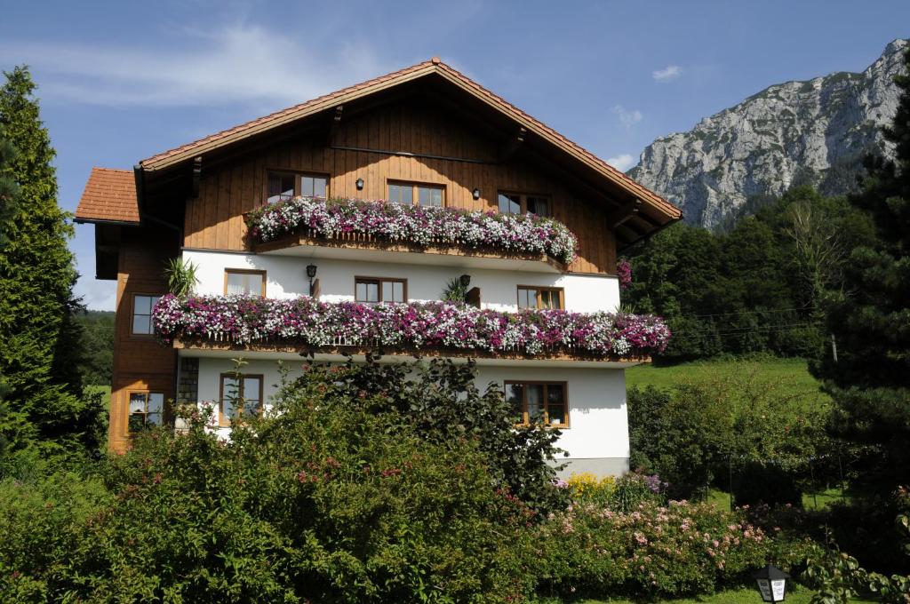 una casa con flores a un lado. en Haus Stückler, en Steinbach am Attersee