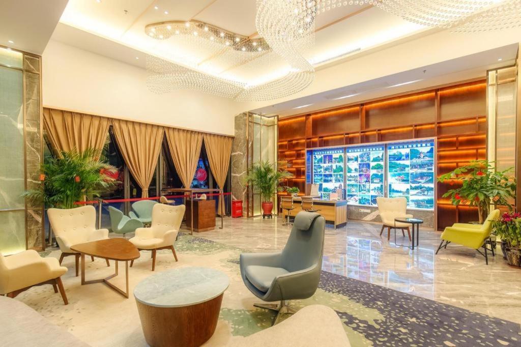 eine Lobby mit Stühlen und Tischen in einem Gebäude in der Unterkunft Guilin Manhatton Hotel Tianjie in Guilin