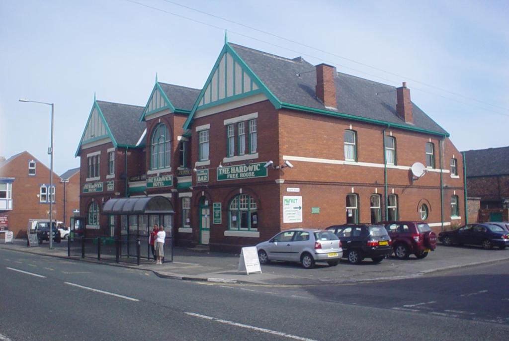 um grande edifício de tijolos com carros estacionados em frente em Hardwick Hotel em Horden