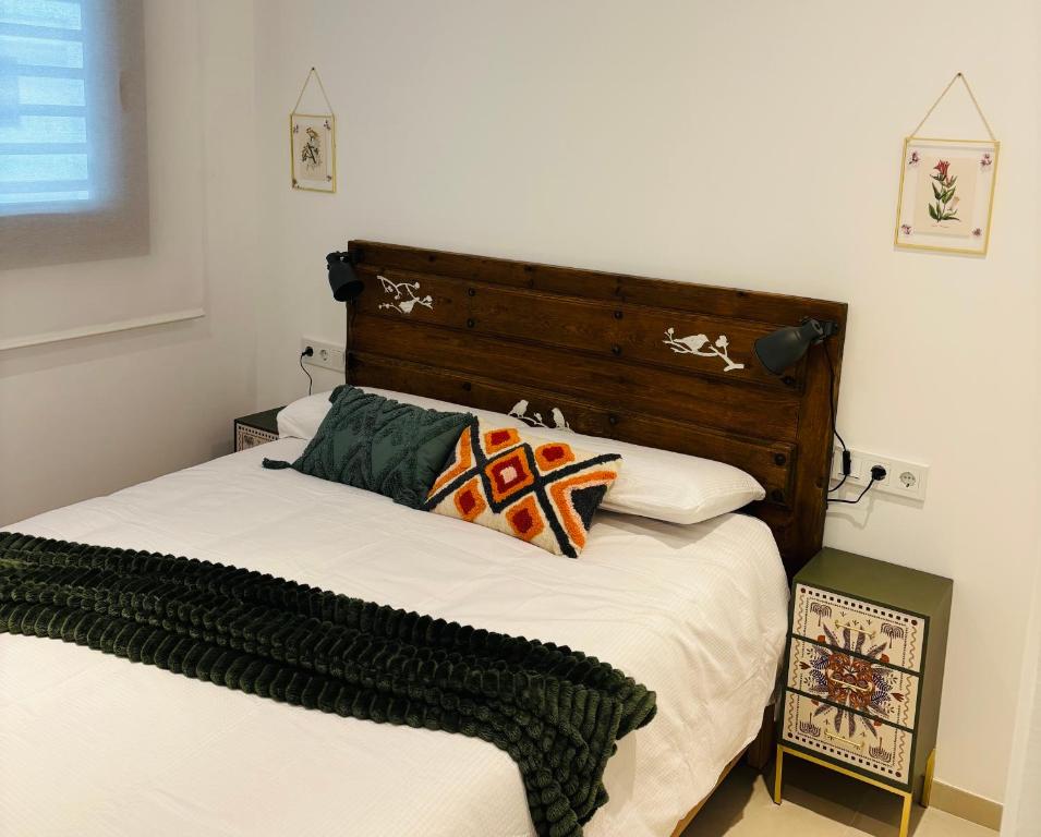 een slaapkamer met een bed met een houten hoofdeinde bij TARIFA MOON The best place to be in Tarifa