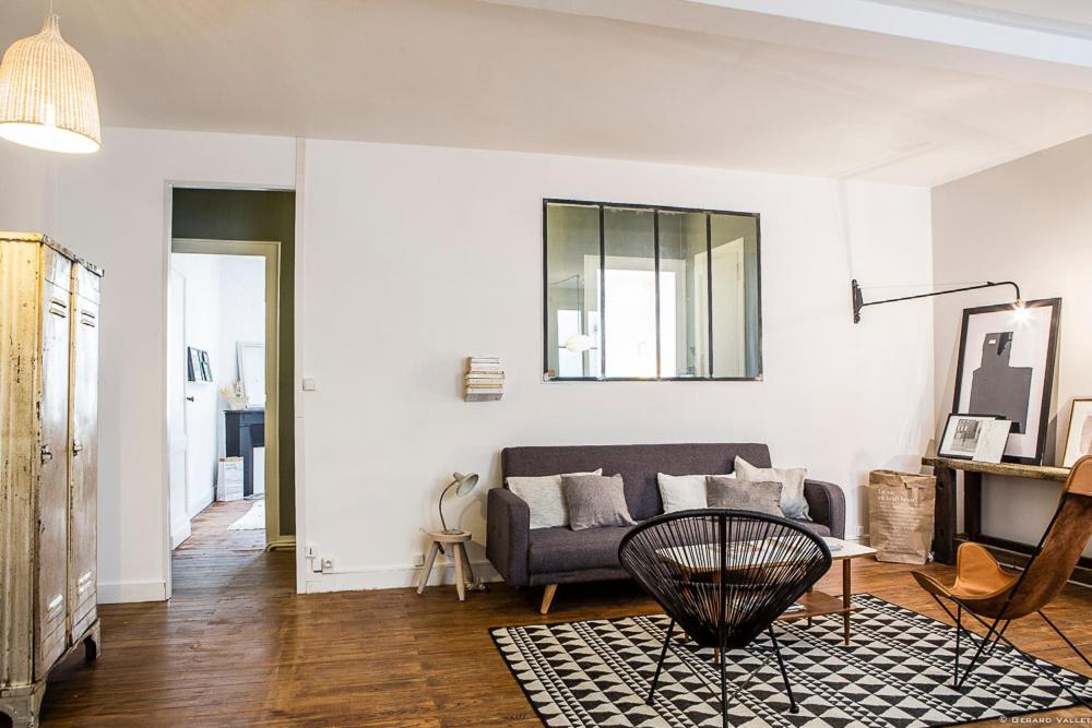 ein Wohnzimmer mit einem Sofa und einem Tisch in der Unterkunft Cheverus in Bordeaux