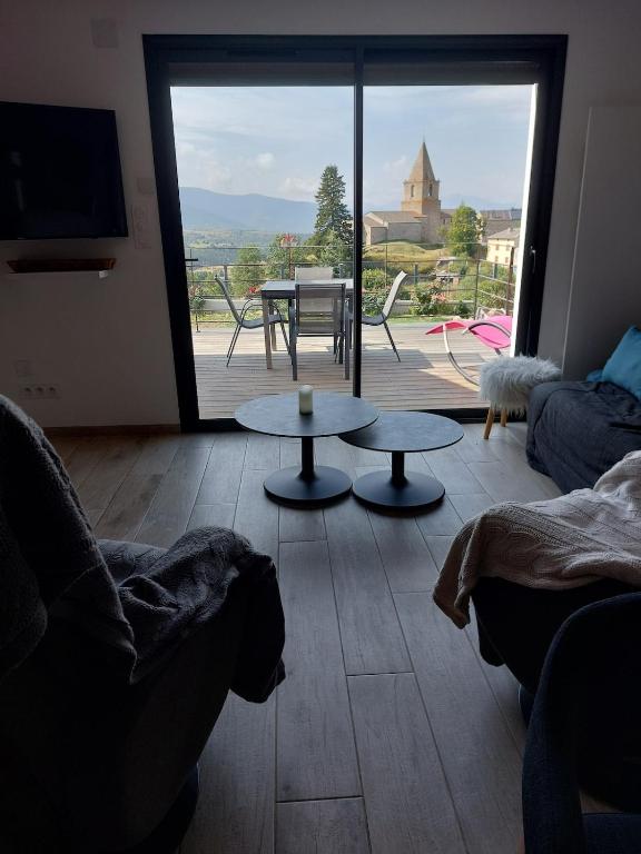 a living room with two tables and a large window at Maison de vacances à la montagne avec vue panoramique in Bolquere Pyrenees 2000