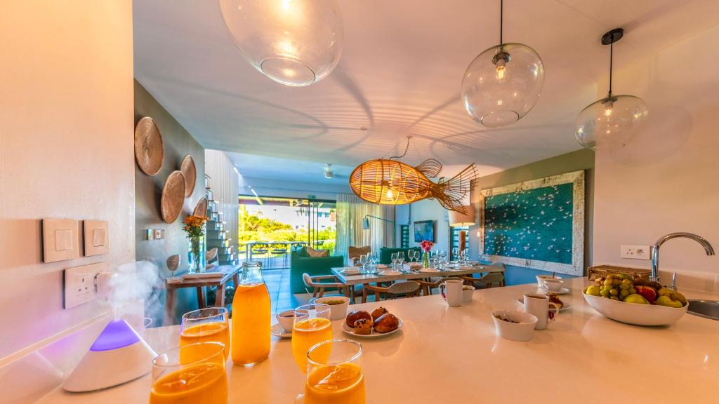 a kitchen with a table with glasses of orange juice at Manta Cove by Horizon Holidays in Tamarin