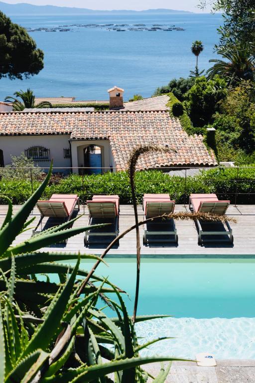 une piscine avec des chaises longues et l'océan dans l'établissement Balamb Garden A Cinarchesa, à Ajaccio