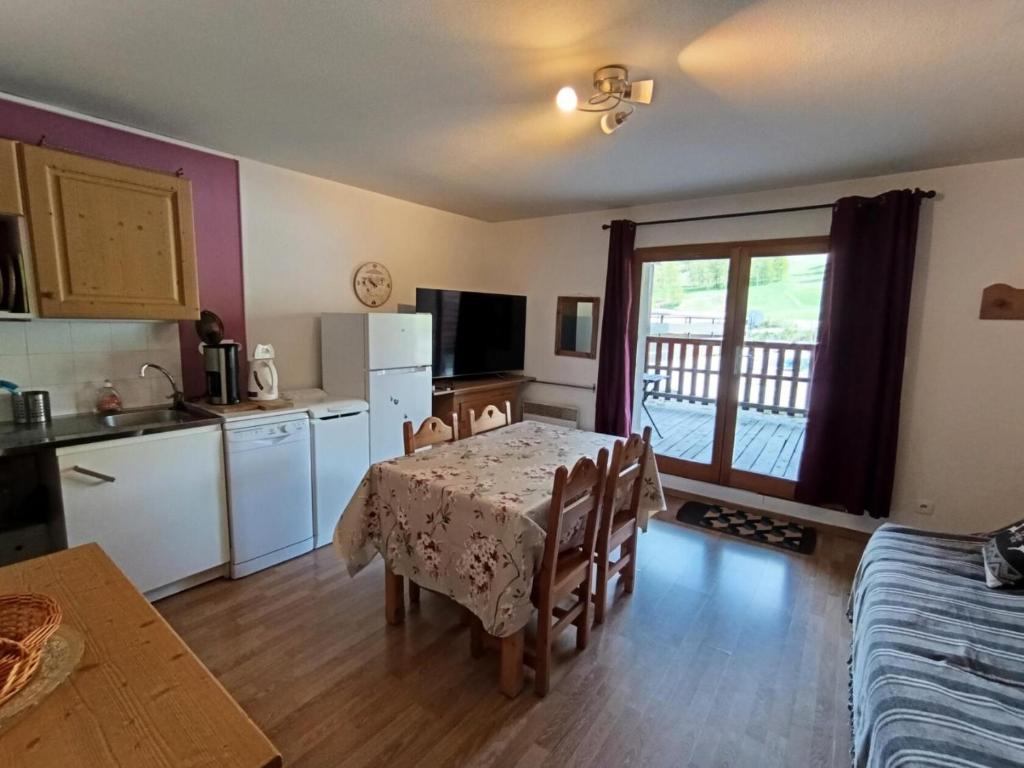une cuisine et une salle à manger avec une table et des chaises dans l'établissement Résidence Neige Et Golf - Front de neige, plein sud, grande terrasse face aux pistes ! MAE-6303, à Montgenèvre