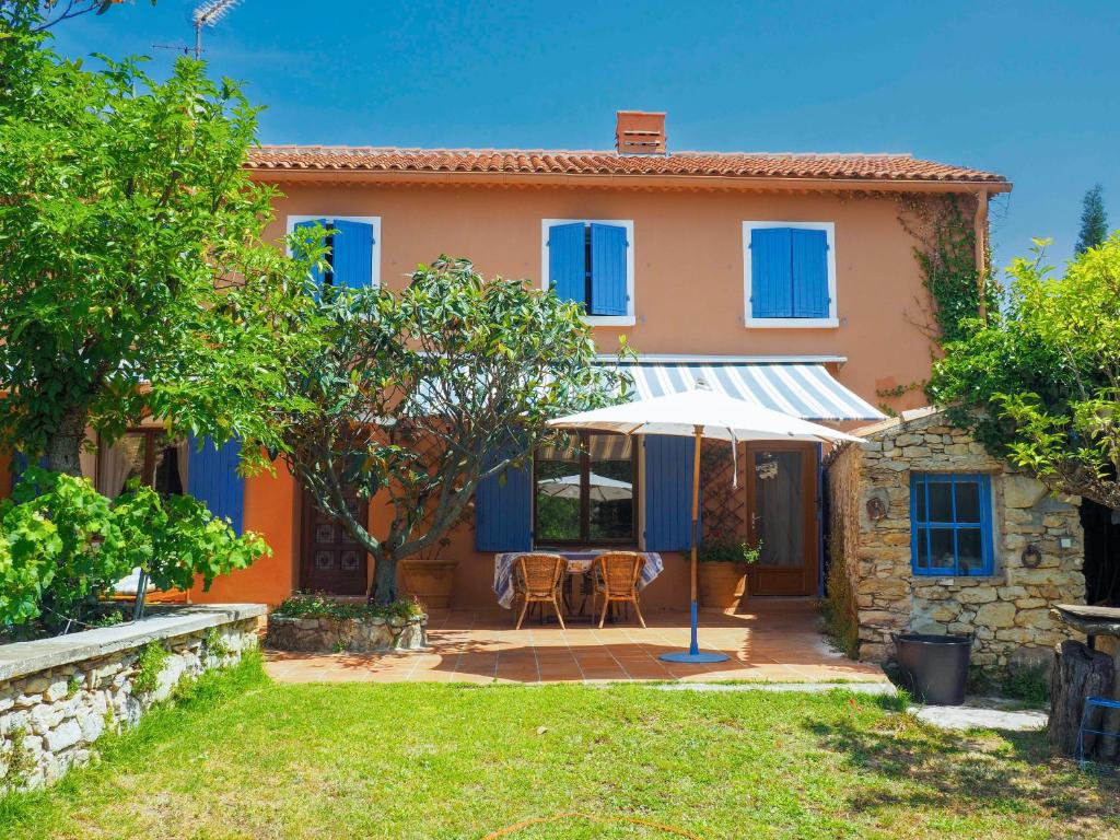 Cette maison dispose de fenêtres bleues et d'une terrasse. dans l'établissement Les Escouradières dans le Var, au Beausset