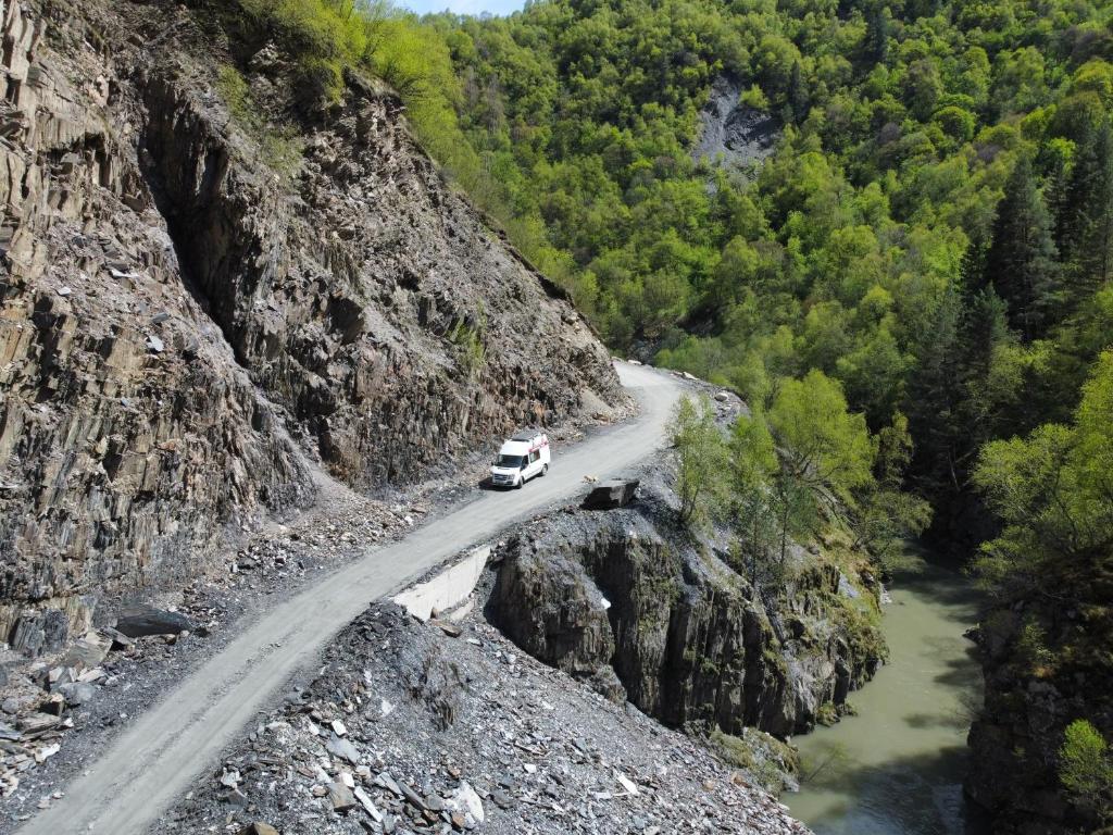 a white car driving down a mountain road at Ford Transit Motorhome-Camper in Batumi