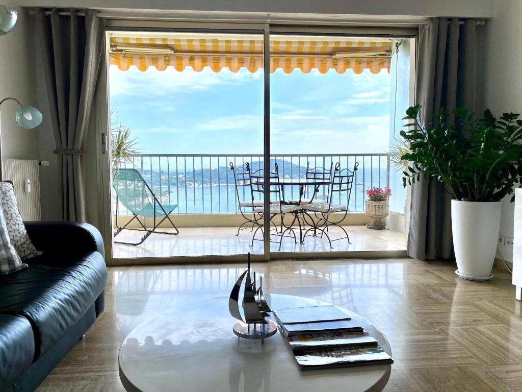 - un salon avec une table et une vue sur l'océan dans l'établissement Le Panomagique, à Villefranche-sur-Mer