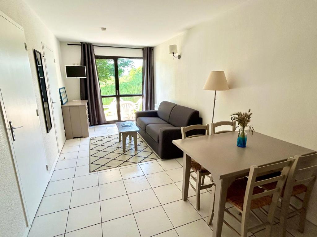 un salon avec une table et un canapé dans l'établissement T2 nature avec terrasse cosy, à Bénodet